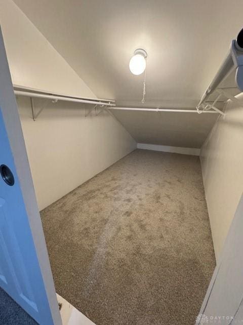 walk in closet with carpet and vaulted ceiling