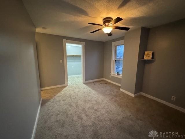 carpeted empty room with a textured ceiling and ceiling fan