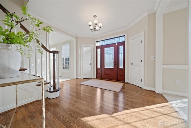 foyer featuring crown molding, a notable chandelier, and hardwood / wood-style flooring