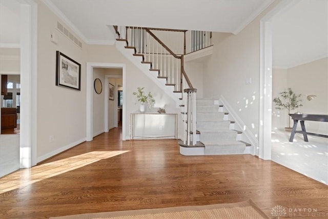 foyer with hardwood / wood-style flooring and ornamental molding