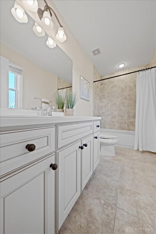 full bathroom featuring tile patterned flooring, vanity, toilet, and shower / tub combo with curtain