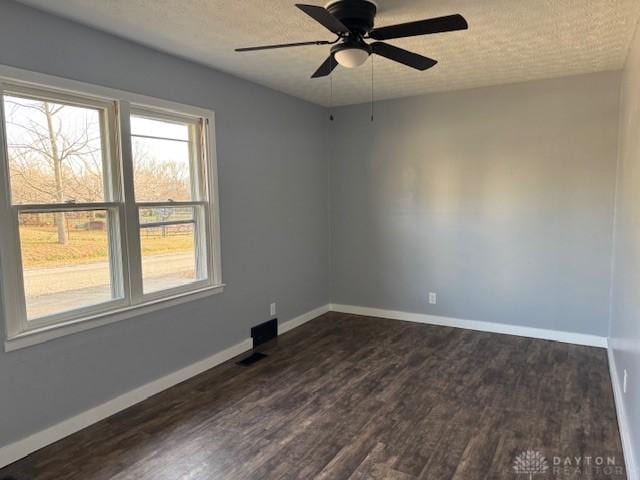 unfurnished room featuring ceiling fan, dark hardwood / wood-style flooring, and a textured ceiling