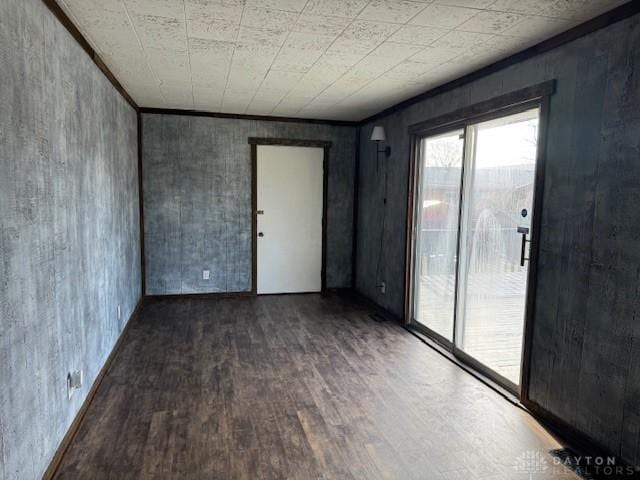 unfurnished room featuring crown molding and dark wood-type flooring