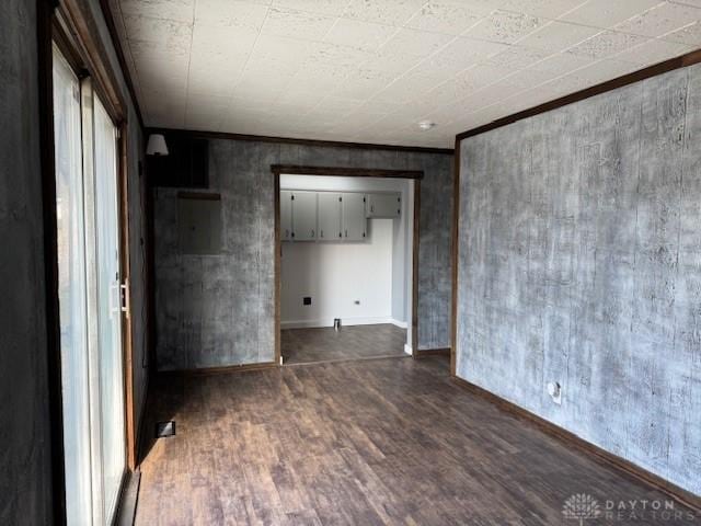 empty room with crown molding and dark hardwood / wood-style flooring