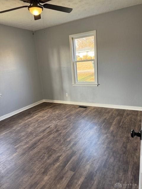 unfurnished room with ceiling fan and dark wood-type flooring