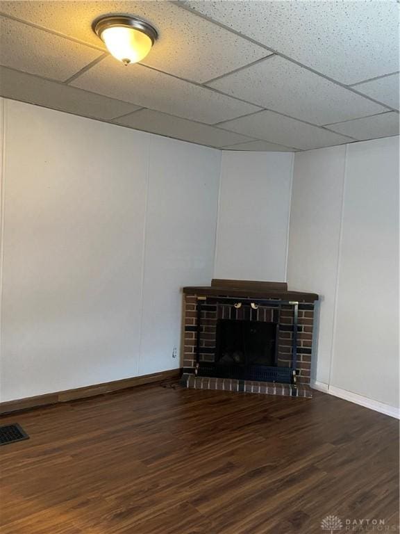 interior space with a fireplace, hardwood / wood-style floors, and a drop ceiling