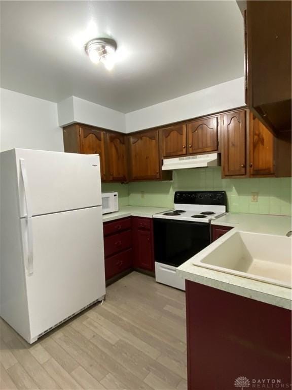 kitchen featuring white appliances, light hardwood / wood-style flooring, and sink