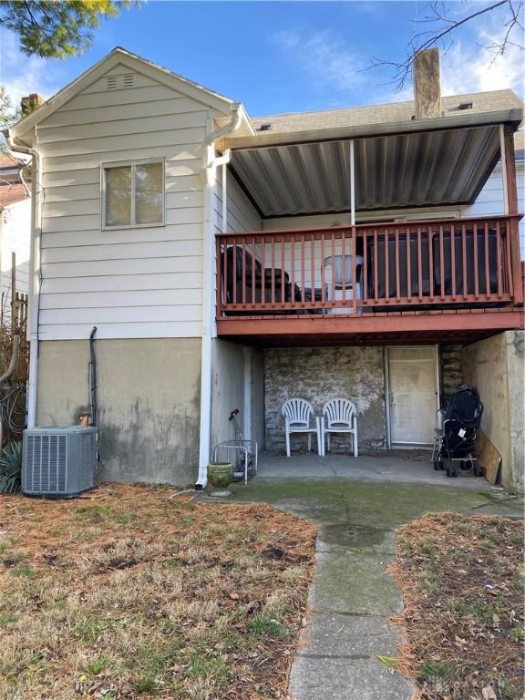 back of property featuring a wooden deck, a patio, and central AC unit