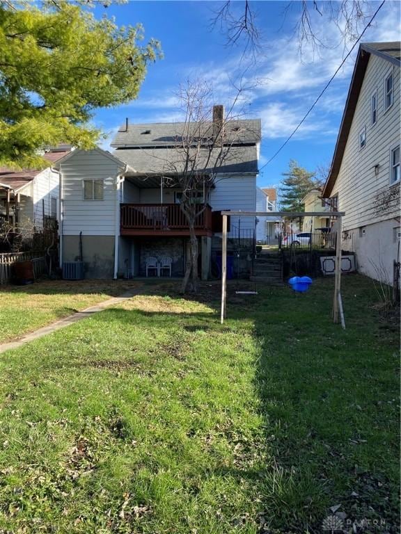 back of house featuring a yard and central AC