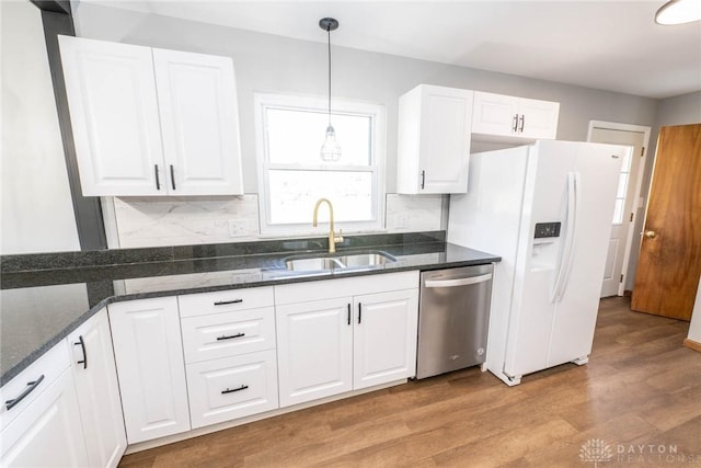 kitchen with sink, dishwasher, white cabinetry, hanging light fixtures, and white fridge with ice dispenser