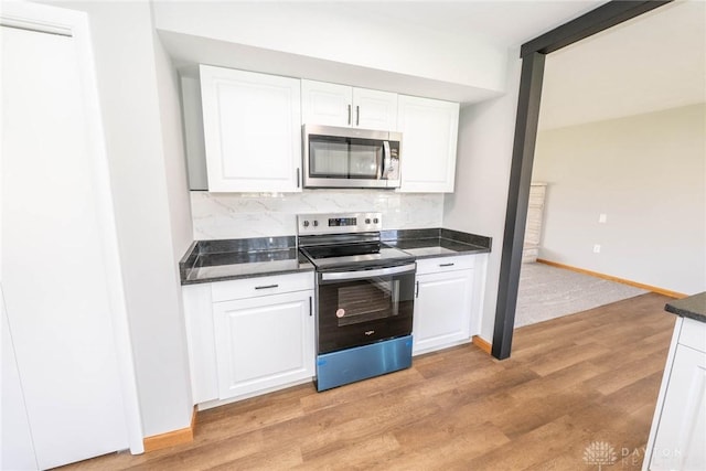 kitchen with stainless steel appliances, white cabinetry, tasteful backsplash, and light hardwood / wood-style floors