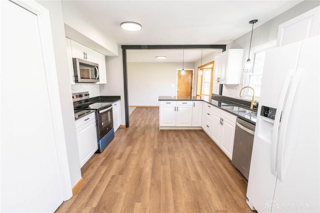 kitchen with sink, white cabinetry, decorative light fixtures, light wood-type flooring, and stainless steel appliances