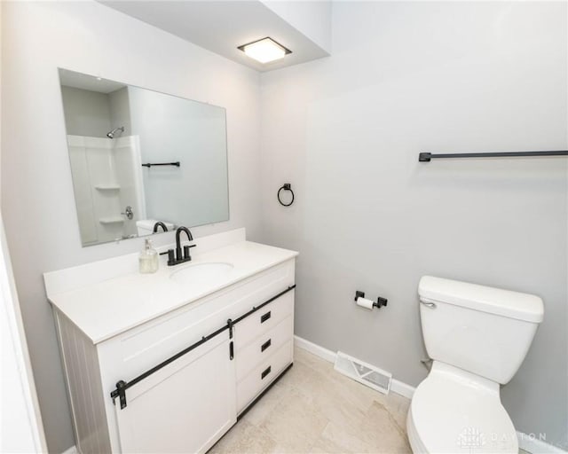 bathroom featuring vanity, a shower, and toilet