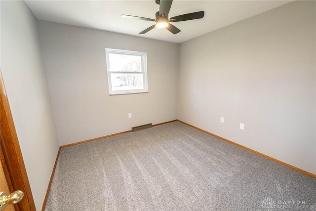 carpeted spare room featuring ceiling fan