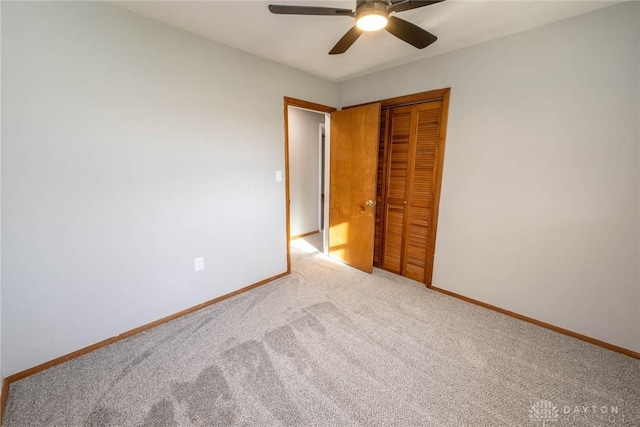 unfurnished bedroom with a closet, ceiling fan, and carpet flooring