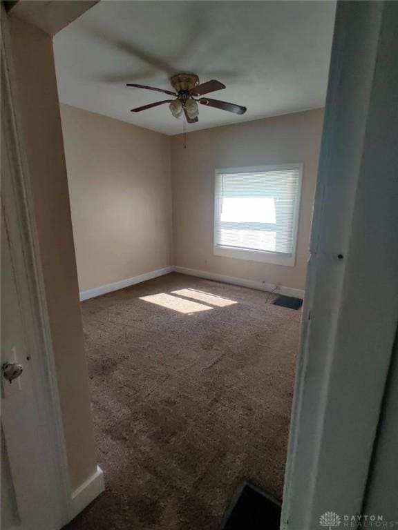 spare room featuring ceiling fan and carpet floors