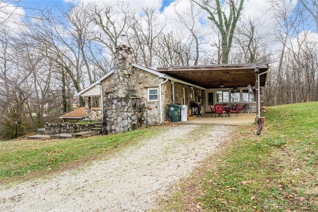 view of home's exterior with a carport and a lawn