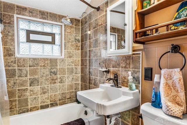 full bathroom featuring sink, tasteful backsplash, bathing tub / shower combination, toilet, and tile walls