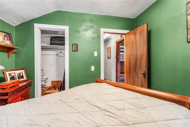 bedroom with a textured ceiling, a closet, and lofted ceiling