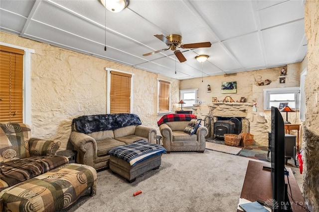 living room with carpet flooring, a wood stove, and ceiling fan