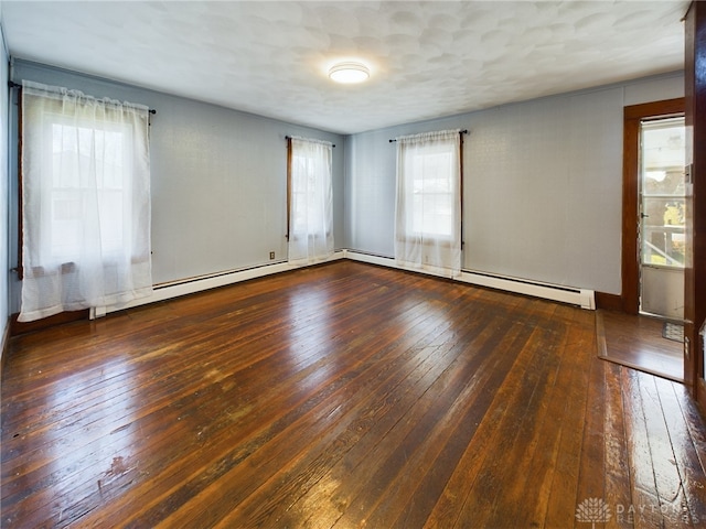 spare room with dark wood-type flooring and a baseboard radiator