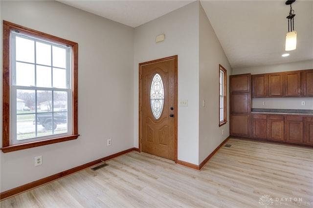 entrance foyer with vaulted ceiling and light hardwood / wood-style flooring