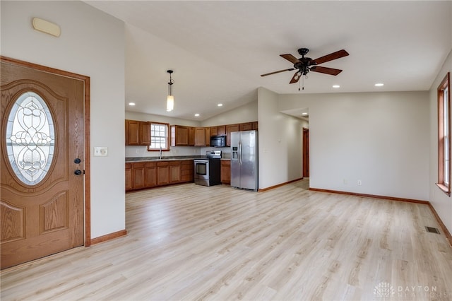 kitchen featuring sink, hanging light fixtures, light hardwood / wood-style flooring, lofted ceiling, and appliances with stainless steel finishes