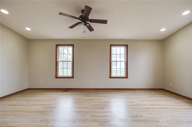 spare room featuring light hardwood / wood-style floors, a wealth of natural light, and ceiling fan