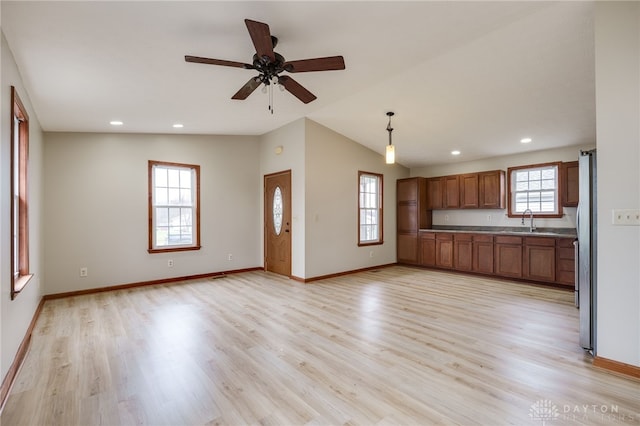 unfurnished living room with ceiling fan, light hardwood / wood-style flooring, lofted ceiling, and sink