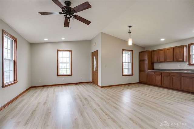 kitchen with ceiling fan, light wood-type flooring, hanging light fixtures, and lofted ceiling