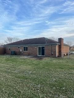 rear view of property featuring a lawn