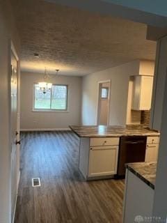 kitchen with kitchen peninsula, dark hardwood / wood-style flooring, white cabinets, and a notable chandelier