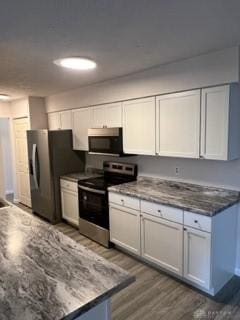 kitchen with white cabinetry, dark wood-type flooring, and appliances with stainless steel finishes