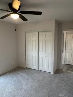 unfurnished bedroom featuring ceiling fan, a closet, and carpet