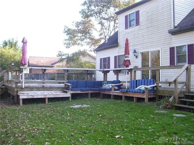 rear view of property featuring a yard, an outdoor hangout area, and a deck