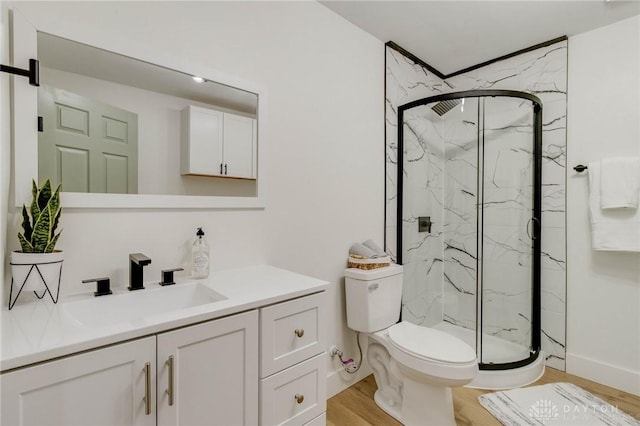 bathroom with hardwood / wood-style flooring, vanity, toilet, and walk in shower