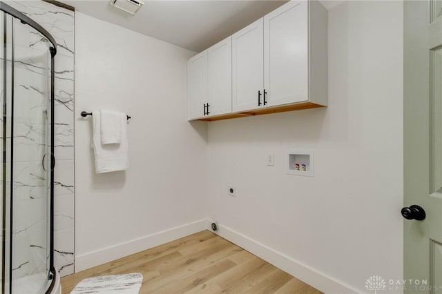 laundry room with cabinets, hookup for an electric dryer, washer hookup, and light hardwood / wood-style flooring