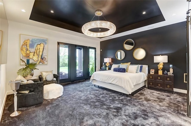 bedroom featuring a raised ceiling, access to exterior, and dark colored carpet