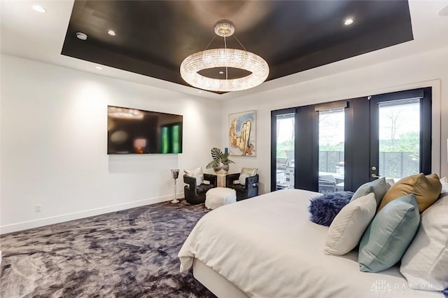 bedroom featuring access to exterior, french doors, carpet flooring, and a raised ceiling