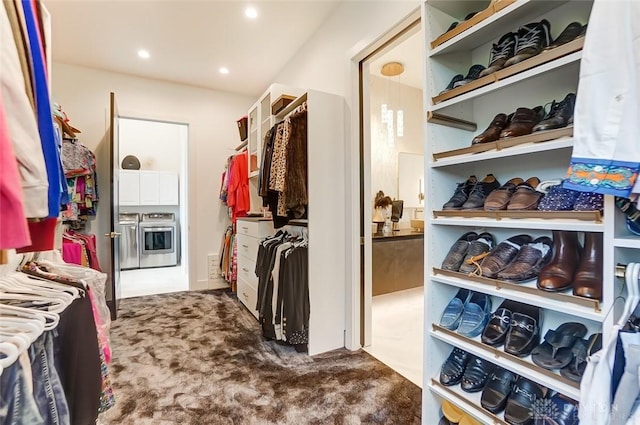 walk in closet with dark colored carpet and washer and clothes dryer