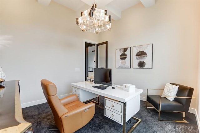 carpeted office space featuring a towering ceiling and an inviting chandelier