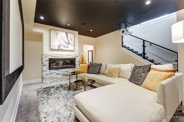 carpeted living room with a stone fireplace