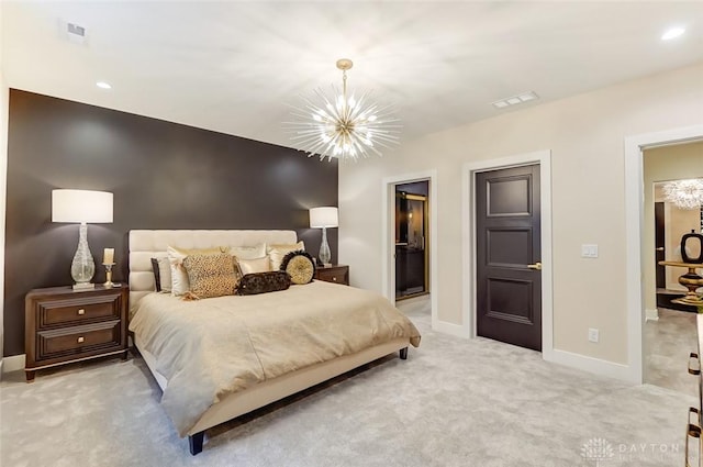 bedroom featuring ensuite bathroom, light carpet, and an inviting chandelier