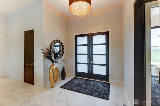 entryway featuring french doors and an inviting chandelier