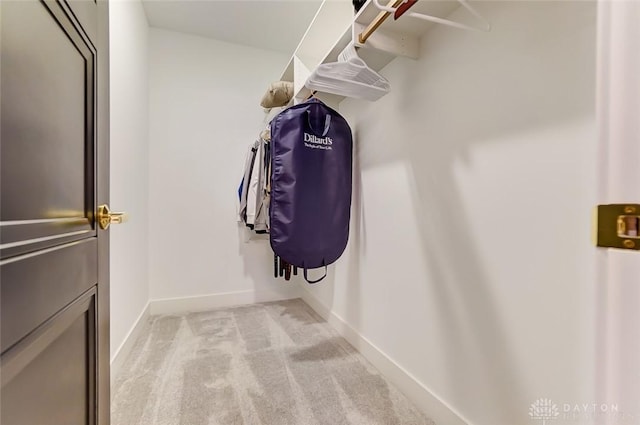 walk in closet featuring light carpet