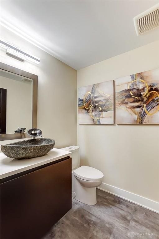 bathroom featuring hardwood / wood-style floors, vanity, and toilet