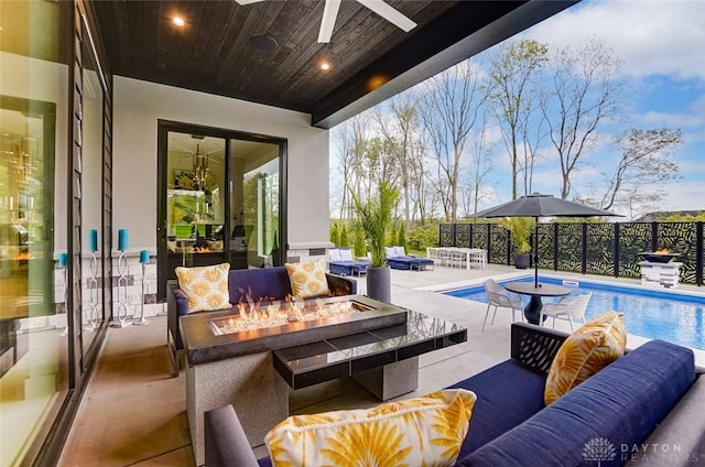 view of pool with an outdoor living space with a fire pit, a patio area, and ceiling fan