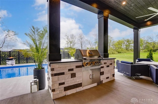 view of patio / terrace with area for grilling, ceiling fan, and exterior kitchen