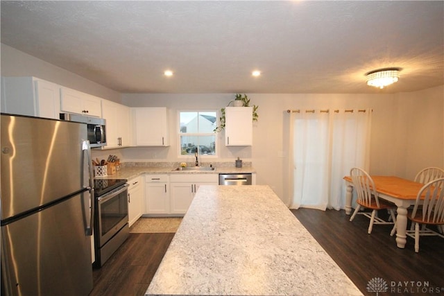 kitchen featuring white cabinets, sink, appliances with stainless steel finishes, and dark wood-type flooring