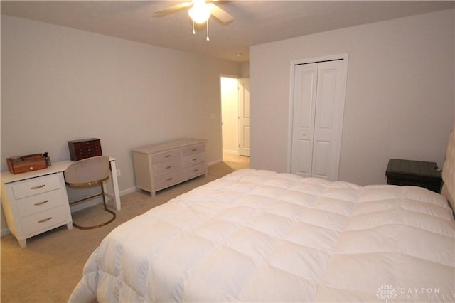 carpeted bedroom with ceiling fan and a closet